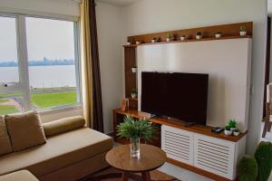 uma sala de estar com um sofá e uma televisão de ecrã plano em Parana Playa 1103 em Encarnación