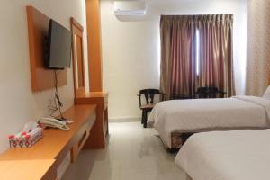 a hotel room with two beds and a flat screen tv at Agape Hotel Haranggaol in Haranggaul