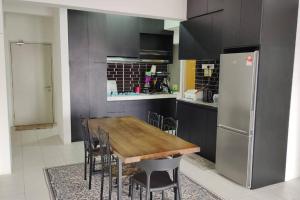 a kitchen with a wooden table and a refrigerator at CANA Homestay Petaling Jaya in Petaling Jaya