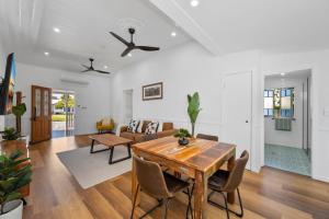 a dining room and living room with a table and chairs at Elegant 3-Bed 2-Bath Cottage: Classic Charm with a Modern Twist in Townsville