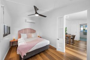 sypialnia z łóżkiem i wentylatorem sufitowym w obiekcie Elegant 3-Bed 2-Bath Cottage: Classic Charm with a Modern Twist w mieście Townsville