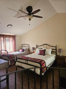 a bedroom with two beds and a ceiling fan at Loft Candelaria Pacaya in Antigua Guatemala