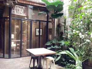 a patio with a table and some plants at The Opposite Place in Melaka