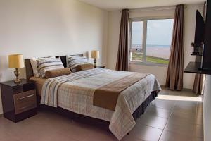 a bedroom with a bed with a view of the ocean at Parana Playa 1103 in Encarnación