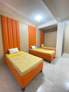 Duas camas num quarto com paredes cor de laranja em XYC Hostel em Tinajero