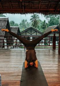 eine Person, die einen Handstand auf einer Yogamatte macht in der Unterkunft Dylan’s Retreat in Lasikin