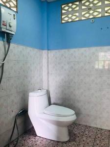 a bathroom with a white toilet in a blue wall at Lee’ s Chill House in Srithanu