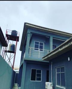 una casa azul con balcón en la parte superior en Beautiful single room studio apartment in Ilasan lekki magnanimous, en Lekki