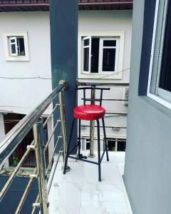 a red stool sitting on a porch next to a window at Beautiful single room studio apartment in Ilasan lekki magnanimous in Lekki