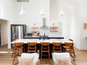 a kitchen with a large white table and chairs at Camp Hideaway Gruene in New Braunfels