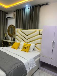a bedroom with a bed with two yellow pillows at Beautiful single room studio apartment in Ilasan lekki magnanimous in Lekki
