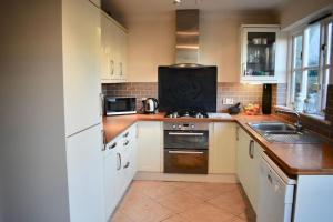 eine Küche mit einer Spüle und einem Herd Top-Backofen in der Unterkunft Lovely 3 Bedroom House South Norwood London in Norwood