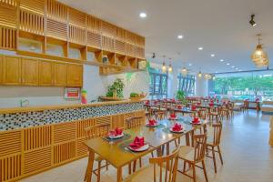 um restaurante com mesas e cadeiras num quarto em Fansipan Da Nang Hotel em Da Nang