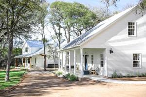an old white house with a driveway at Camp Hideaway Gruene in New Braunfels