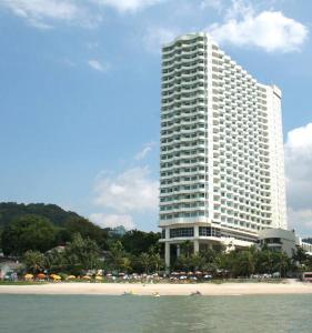 a large white building next to a beach with a building at Rainbow Paradise Homestay @ Tanjung Bungah by Landmark in Tanjung Bungah