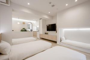 a bedroom with two beds and a flat screen tv at STAY ARI Shinjuku Gyoen 6Min walk in Tokyo