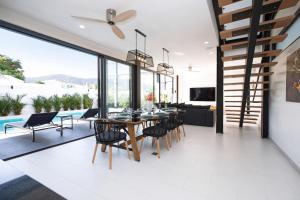 a dining room with a table and chairs at New 2-Storey Villa*4BR*Eco-Pool Sunset Garden 8 in Ban Saiyuan (1)
