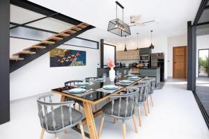 a dining room with a long wooden table and chairs at New 2-Storey Villa*4BR*Eco-Pool Sunset Garden 8 in Ban Saiyuan (1)