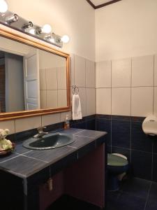 La salle de bains est pourvue d'un lavabo, d'un miroir et de toilettes. dans l'établissement Chavenogue Hotel, à San Juan
