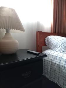 eine Lampe auf einem Tisch neben einem Bett in der Unterkunft Chavenogue Hotel in San Juan