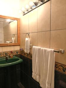 a bathroom with a sink and a mirror and towels at Chavenogue Hotel in San Juan