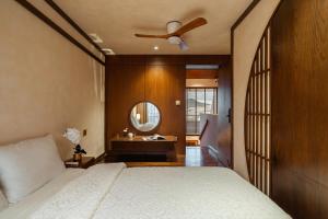 a bedroom with a bed with a ceiling fan and a mirror at Biệt Thự Nam Hồ Đà Lạt - Villa Luxury Nam Hồ in Khu Chi Lăng