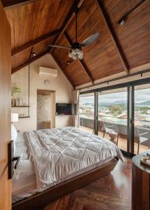 een slaapkamer met een bed en een plafondventilator bij Biệt Thự Nam Hồ Đà Lạt - Villa Luxury Nam Hồ in Khu Chi Lăng