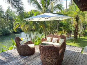 a patio with two chairs and an umbrella at Nanai Resort Salakphet in Ko Chang