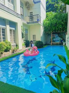 une femme monte un radeau gonflable dans une piscine dans l'établissement 22 ba trieu phuong 1 thanh pho vung tau, à Vung Tau