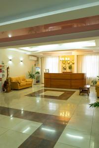 a lobby with a waiting room with a yellow couch at Victoria Palace in Atyraū