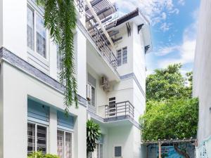 - un bâtiment blanc avec des balcons sur le côté dans l'établissement 22 ba trieu phuong 1 thanh pho vung tau, à Vung Tau