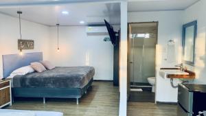 a bedroom with a bed and a bathroom with a sink at Be Happy Hotel in San Andrés