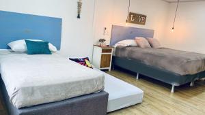 a bedroom with two beds and a night stand at Be Happy Hotel in San Andrés