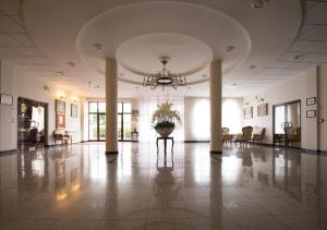 a large lobby with a potted plant in the middle at Hotel Chopin in Sochaczew
