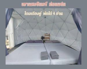 Bett in einem Zelt mit zwei Kissen in der Unterkunft เขาเเสงจันทร์ ม่อนเเจ่ม 4 in Mon Jam