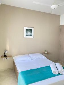 1 dormitorio con 1 cama y una foto en la pared en Guakmaya hostel, en Cartagena de Indias