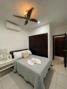 um quarto com uma cama e uma ventoinha de tecto em Moderno y acogedor condominio em San Pedro Sula