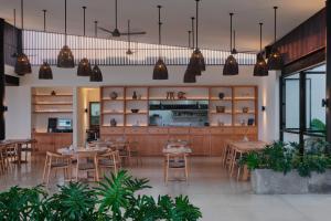 a restaurant with wooden tables and chairs and potted plants at Somewhere Lombok in Kuta Lombok