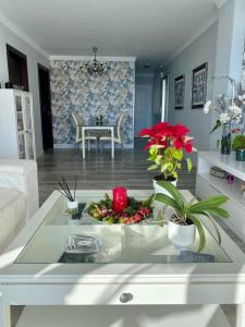una sala de estar con una mesa con un arreglo floral en APARTAMENTO CON VISTAS AL MAR, en Torremolinos