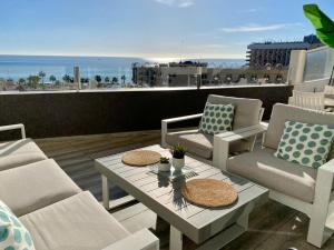 un patio con sillas y una mesa con vistas al océano en APARTAMENTO CON VISTAS AL MAR, en Torremolinos
