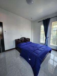 um quarto com uma cama com um edredão azul em Baan Fah Chiang Rai em Mae Salong Nai
