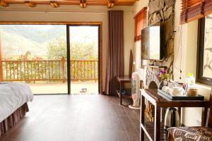 a bedroom with a bed and a sliding glass door at Vân Hồ Ecolodge in Mộc Châu