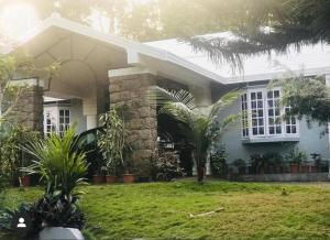 a house with a green lawn in front of it at The Mallika Holidays in Mananthavady