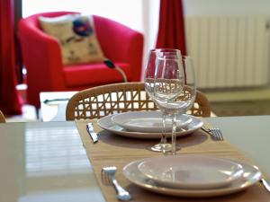 - une table avec deux assiettes et un verre de vin dans l'établissement Apartamentos La Machacona Plaza de Santiago, à Cáceres