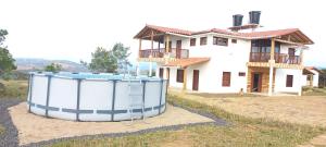une maison avec un grand réservoir d'eau devant elle dans l'établissement CASA CAMPESTRE VILLA COVA Da IRIA BARICHARA, à Barichara