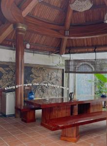 um quarto com uma mesa de madeira e um banco em The Memory Villa - Mộc Châu em Mộc Châu