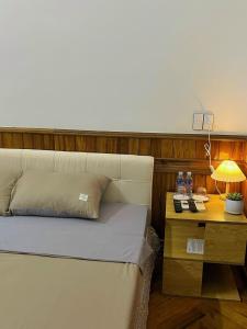 um quarto com uma cama e uma mesa com um candeeiro em The Memory Villa - Mộc Châu em Mộc Châu