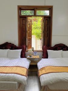Duas camas num quarto com uma janela em The Memory Villa - Mộc Châu em Mộc Châu