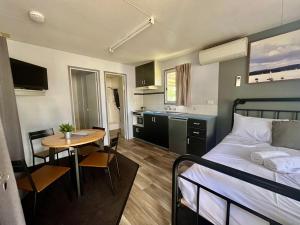 1 dormitorio con cama, mesa y cocina en Young Caravan and Tourist Park en Young