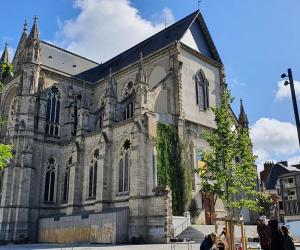 una vieja iglesia con gente parada frente a ella en Parlement - Beau Studio, en Rennes